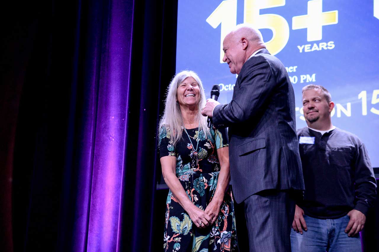 Truck drivers who've driven for Prime Inc. for 15+ years being honored on-stage at the 10-year dinner by Robert Low.