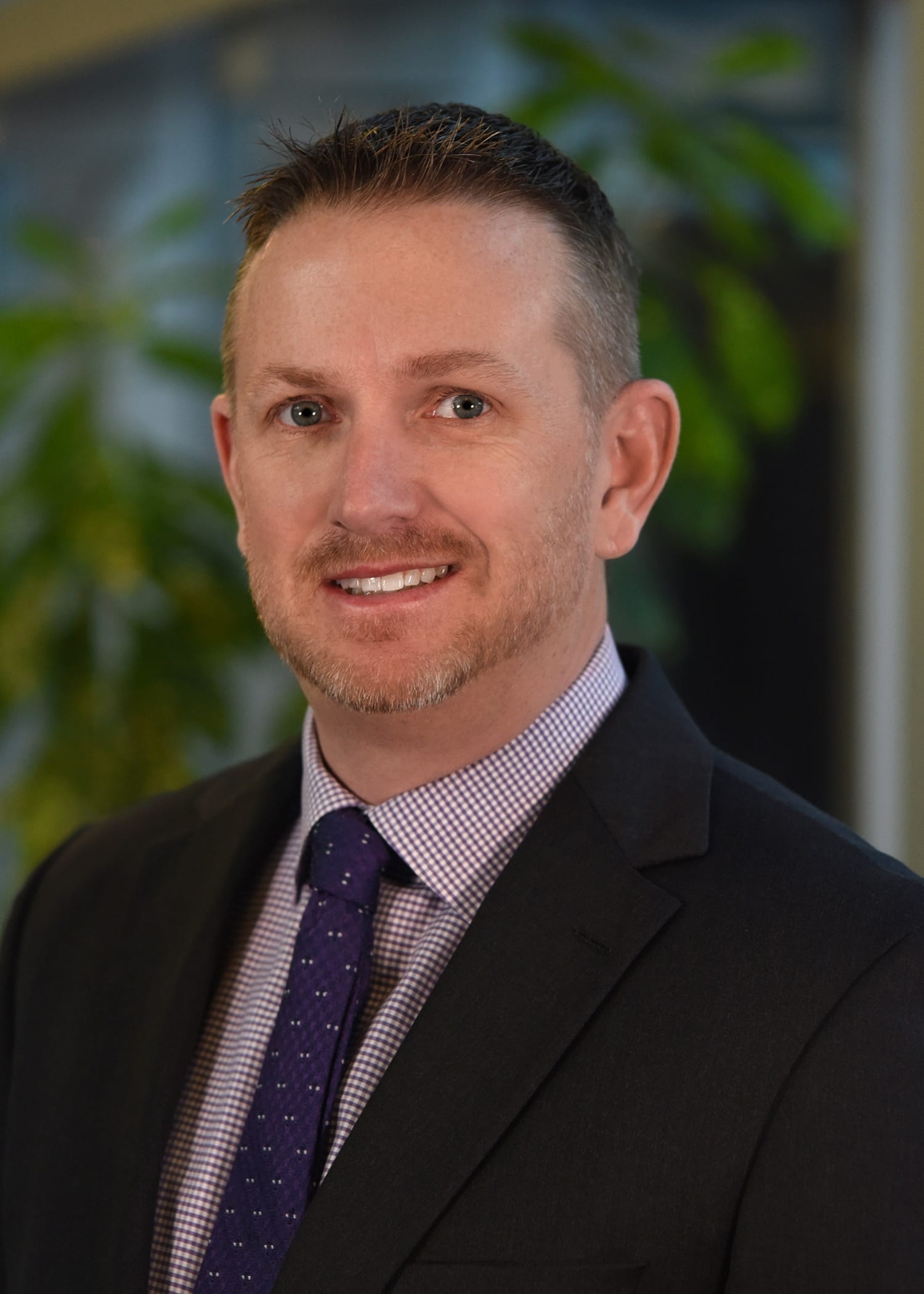 Ryan Harrington, Manager of Prime's Intermodal Division, wearing a suit jacket & red checkered tie.